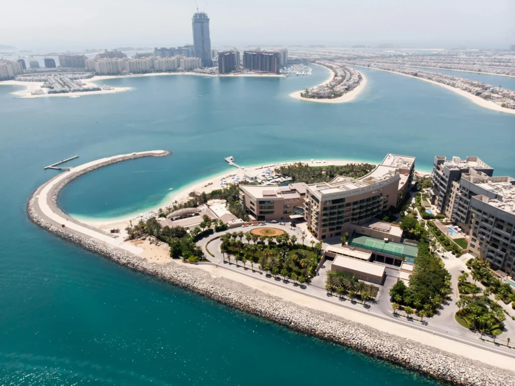 Elegant luxury home by the ocean with a dock and boat showcasing the refined lifestyle of Jumeirah Bay Island Mansions.