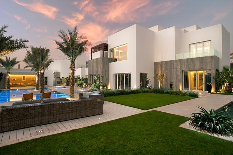 A contemporary mansion on Jumeirah Bay Island featuring a pool and solar panels, highlighting sustainable living.